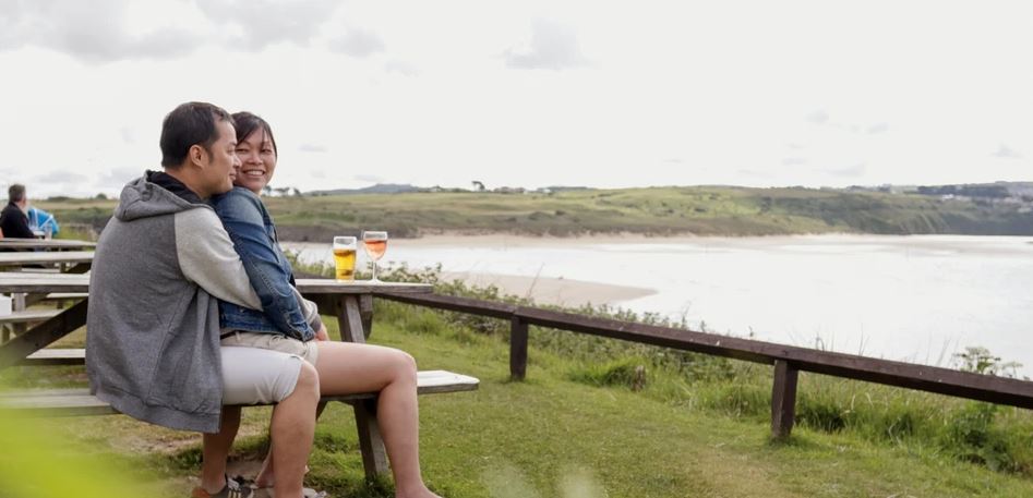 A couple in an embrace overlooking the beach below