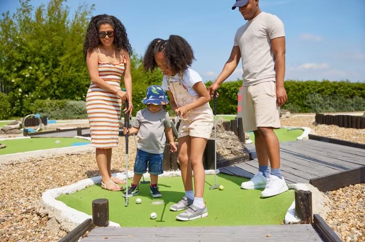 A family playing crazy golf on Allhallows caravan park Kent