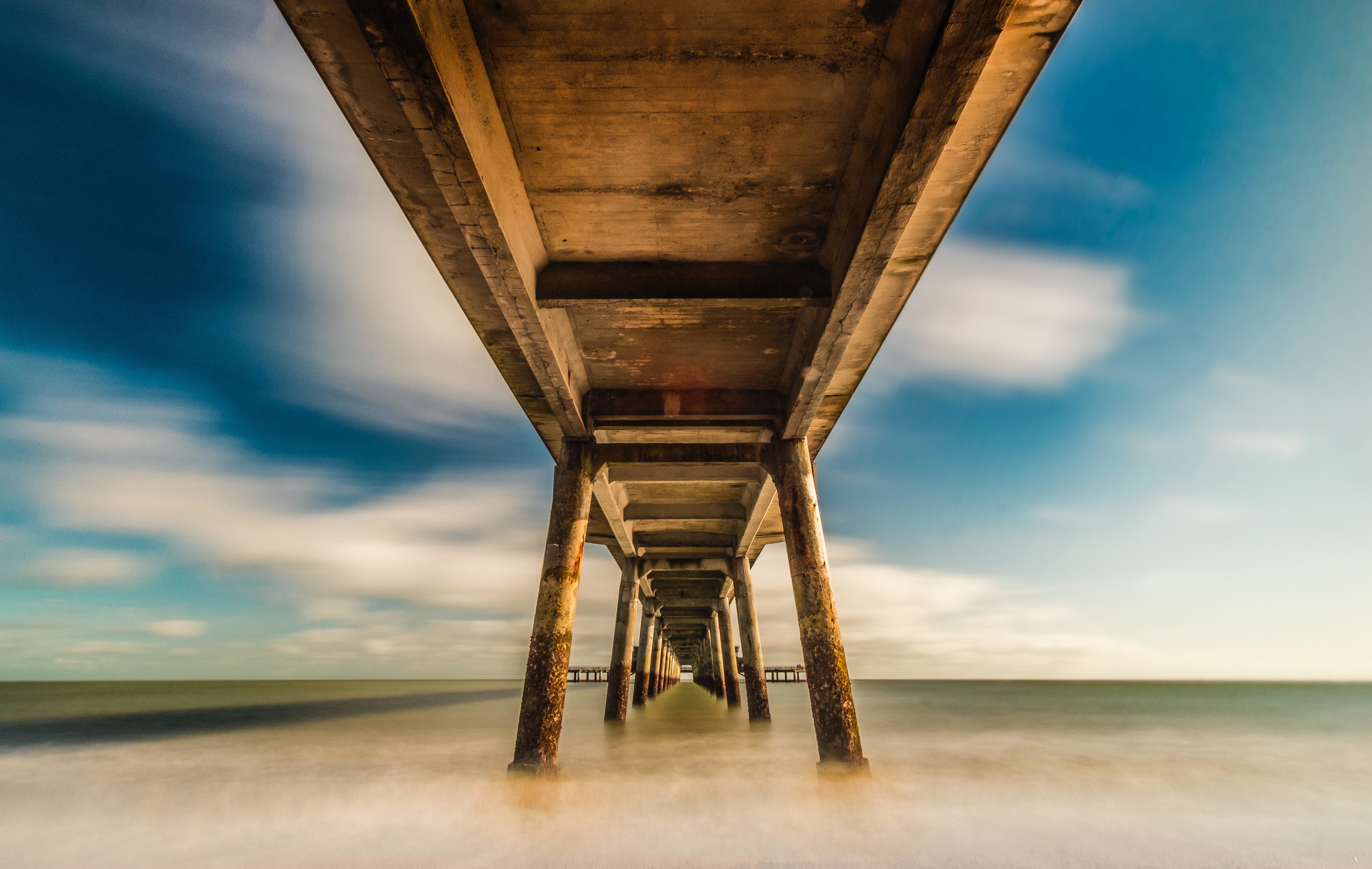 A view from under a pier looking out to sea
