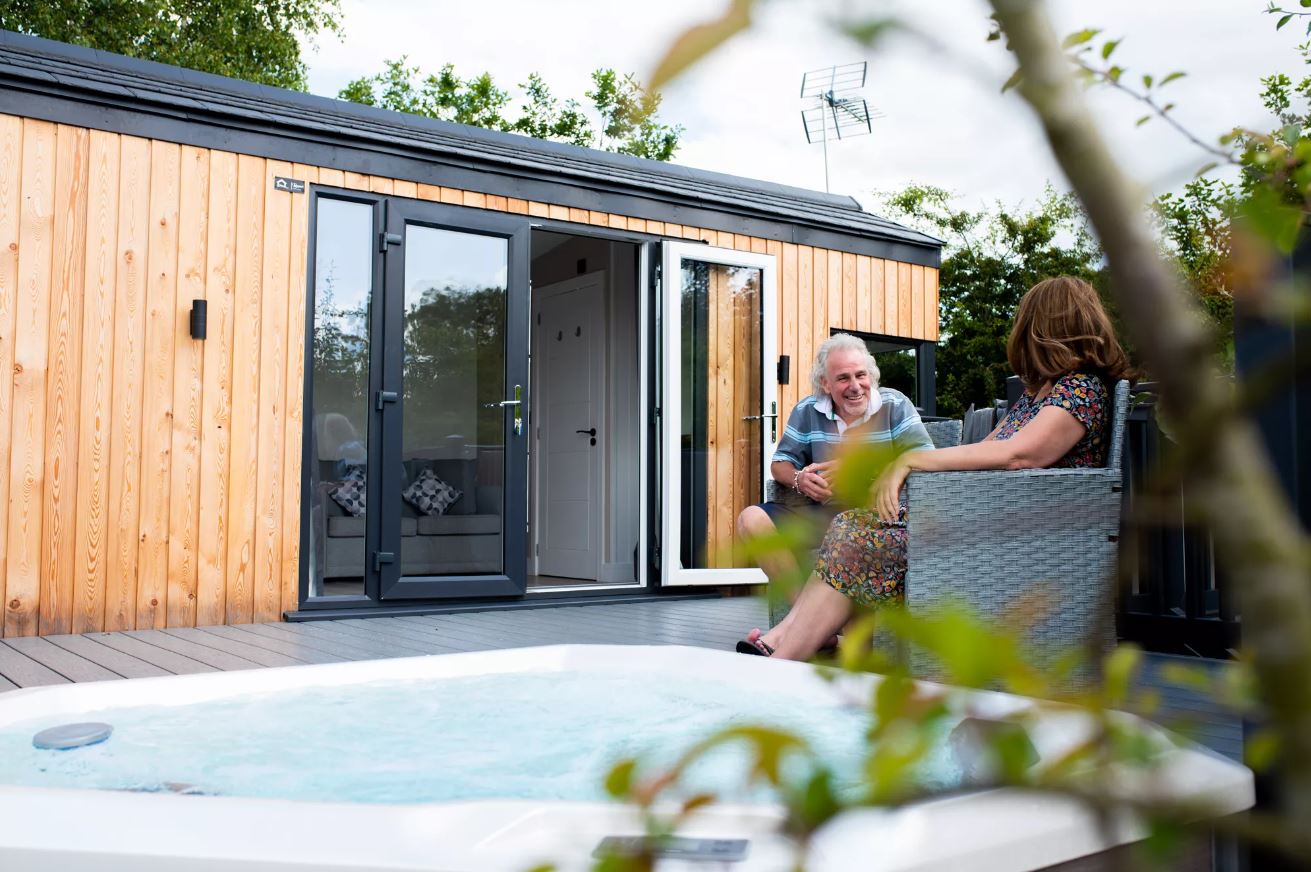 A couple sitting on the deck area of their holiday home