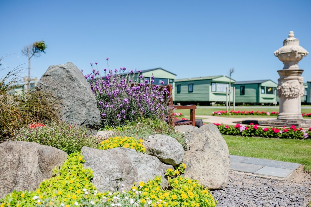 Holiday homes surrounded by flowers/ plants and statue ornaments