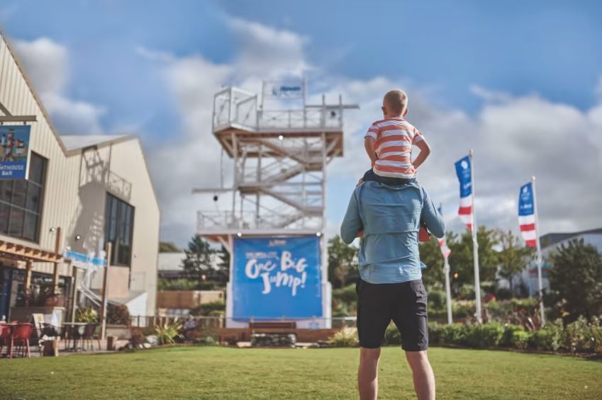 A child on it's parents shoulders in a holiday park