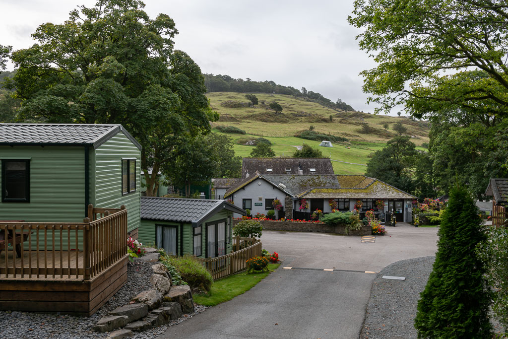 A number of holiday homes surrounded by trees and rolling hills