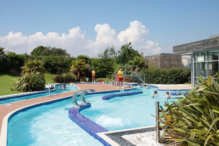 An image of a swimming pool on a warm sunny day with lifeguards on duty