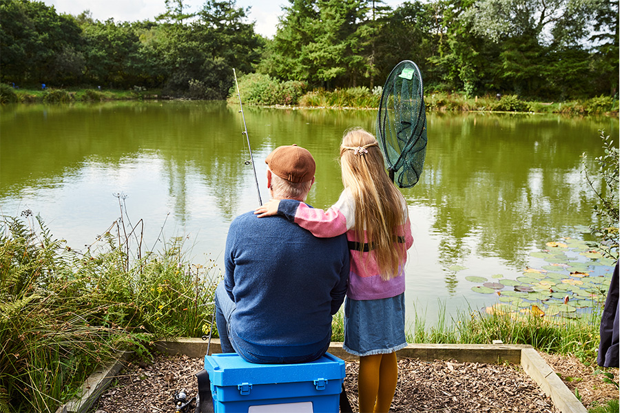 A Grandfather and Grandaughter Fishing at a Cornish Lakeside