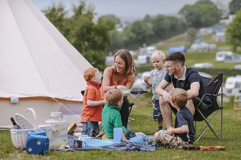 A Family Sitting Beside their Tent on a Holiday Park in Devon