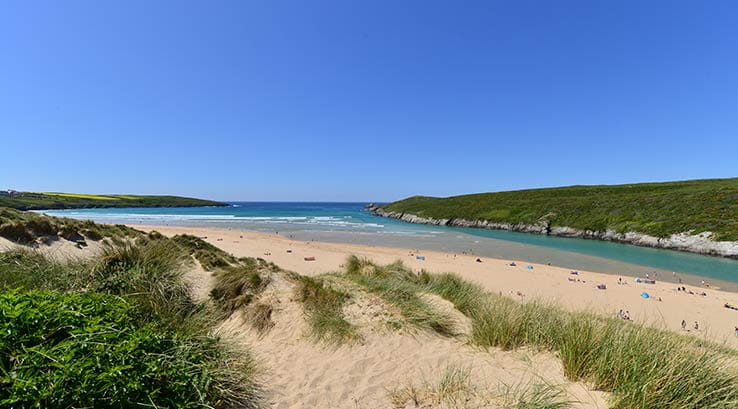 People Dotted along the Shoreline at Crantock Beach in Cornwall