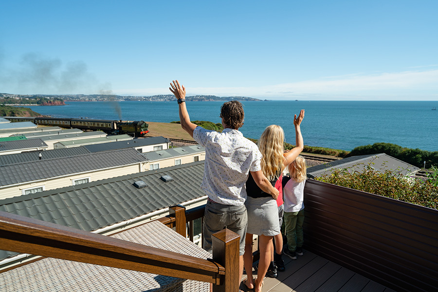 A Family Waving at the Steam Train Passangers with Far Reaching Coastal Views of South Devon