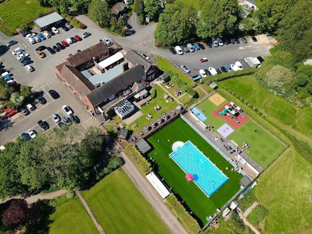 A View of a Swimming Pool, Childrens Play Area, Club House, Golf Green and Car Park from Above