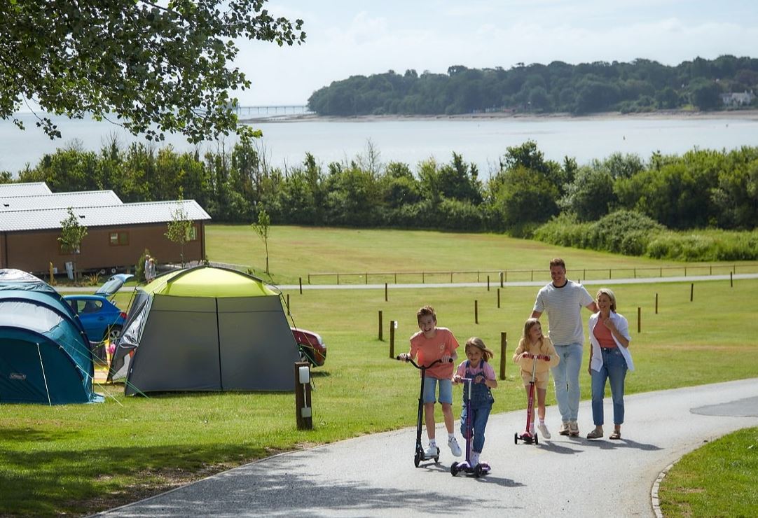 A Family Walking Through  Holiday Park near the Beach on a Bright Sunny Day