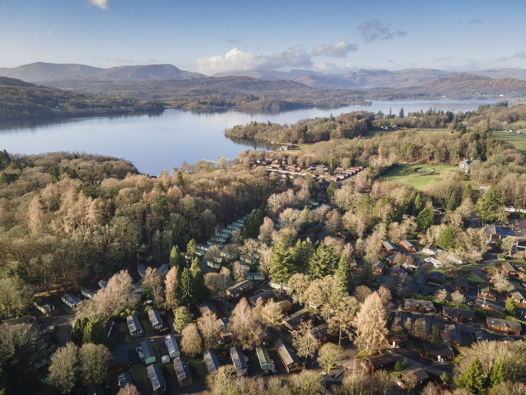 An Arial view of a Holiday Parked Nestled in the Woods at the Side of a Lake