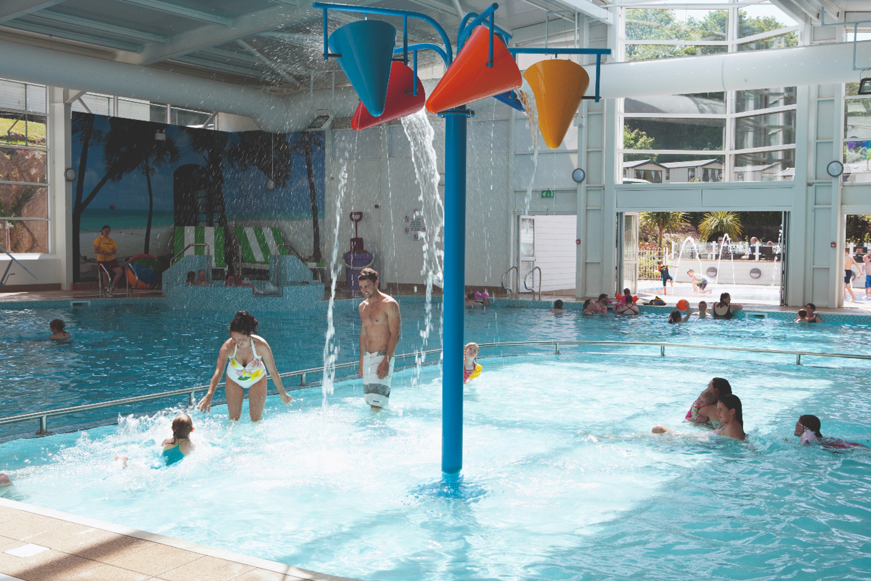 Indoor Swimming Pool with Tipping Water Buckets above People on a Holiday Park
