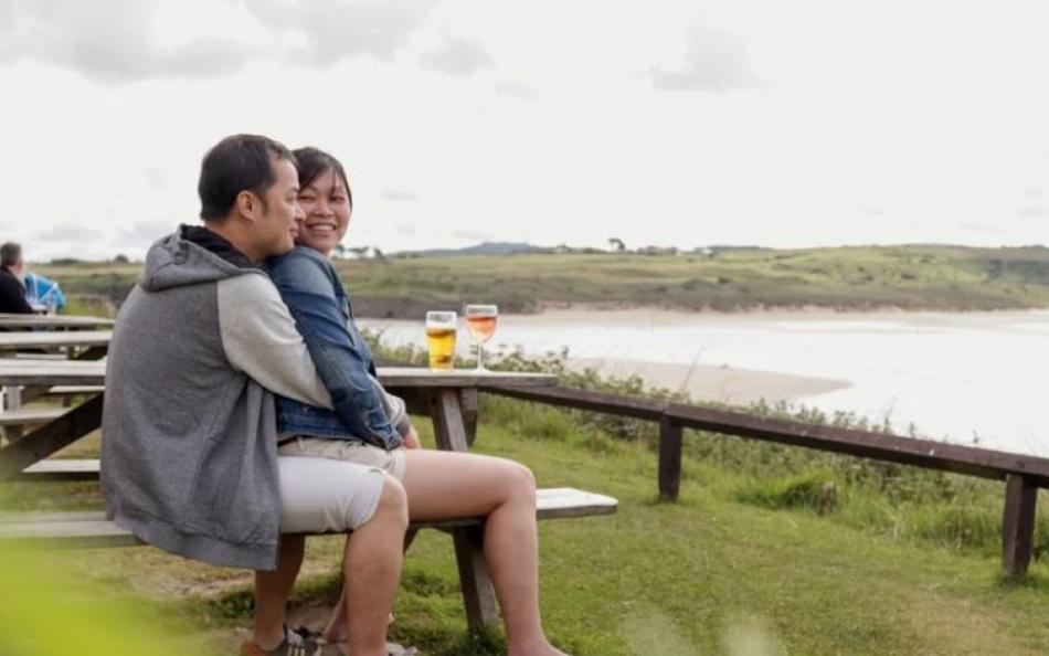 A couple in an embrace overlooking the beach below