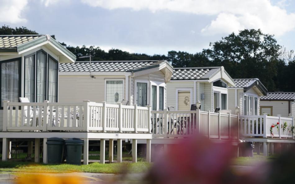 A row of holiday homes surrounded by woodland and flower gardens