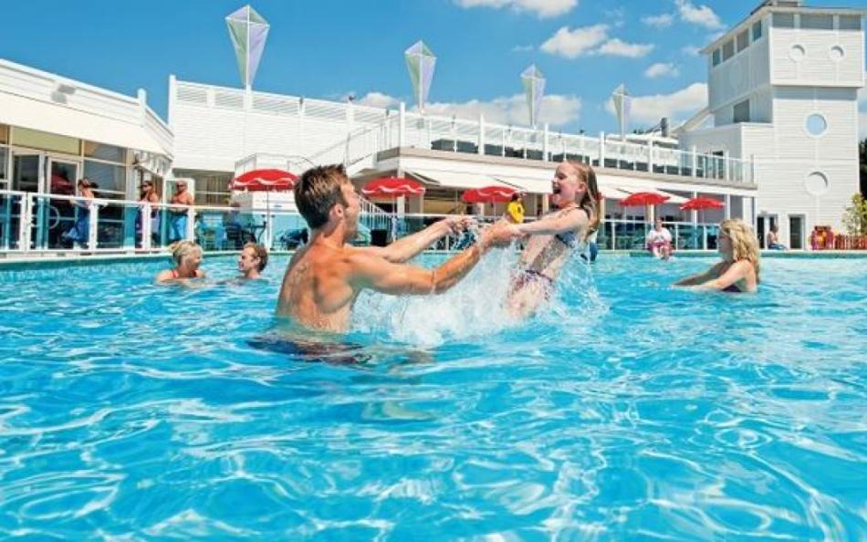 A dad playing in an outdoor pool at Rockley Park for pet friendly family holiday in Dorset