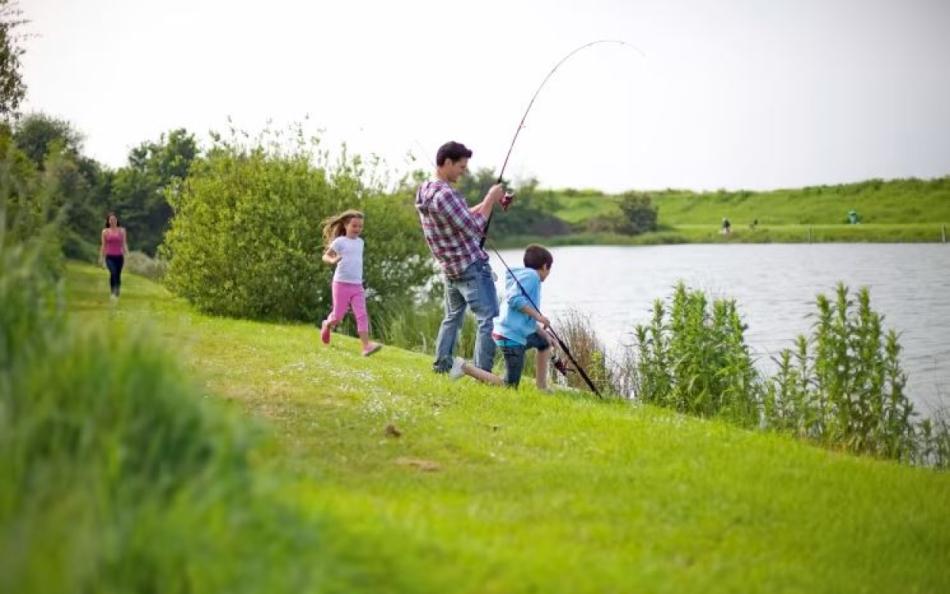 A family fishing at the side of a holiday park lake