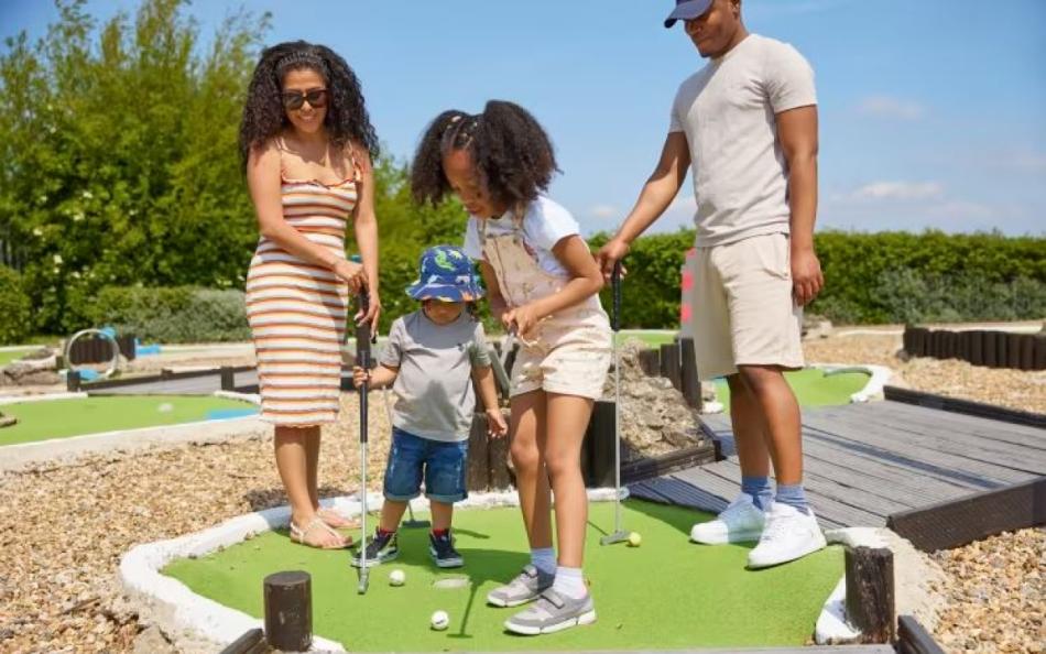 A family playing crazy golf on Allhallows caravan park Kent