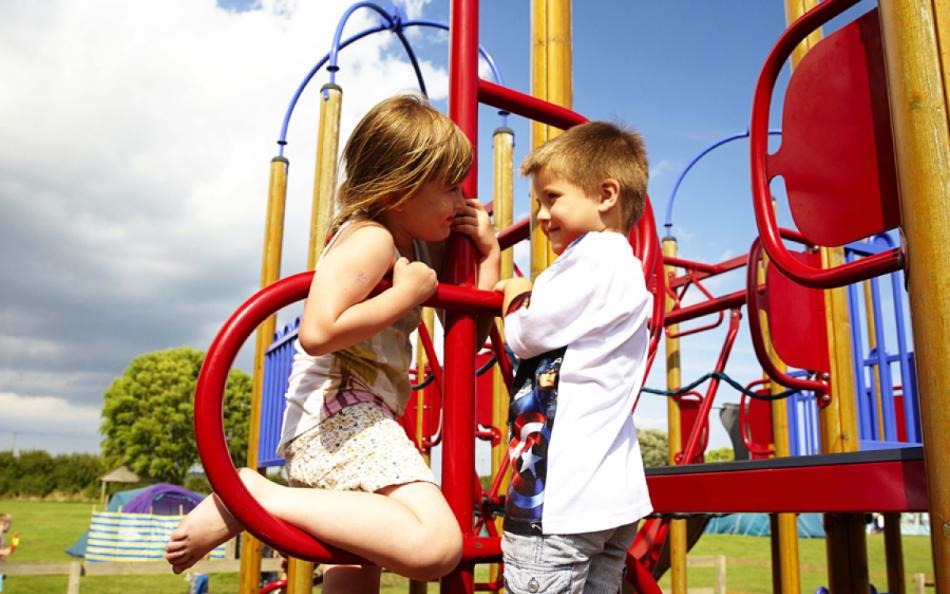 two children talking on a play park at New Beach Holiday Park Kent 