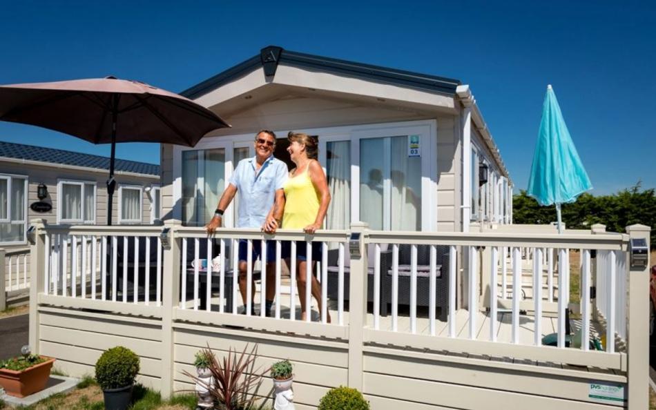 A couple on the balcony of their holiday home in the sunshine