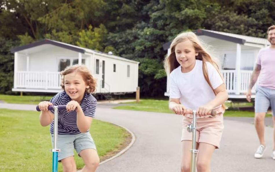 Two children on scooters at Thorpe Park Holiday Centre Lincolnshire caravan park