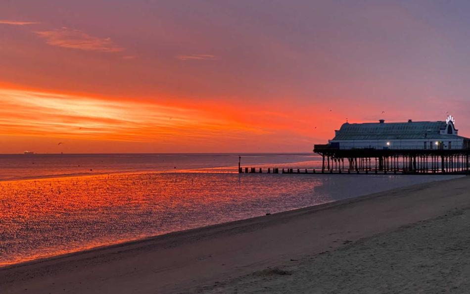 A sunset over Cleethorpes beach and pier