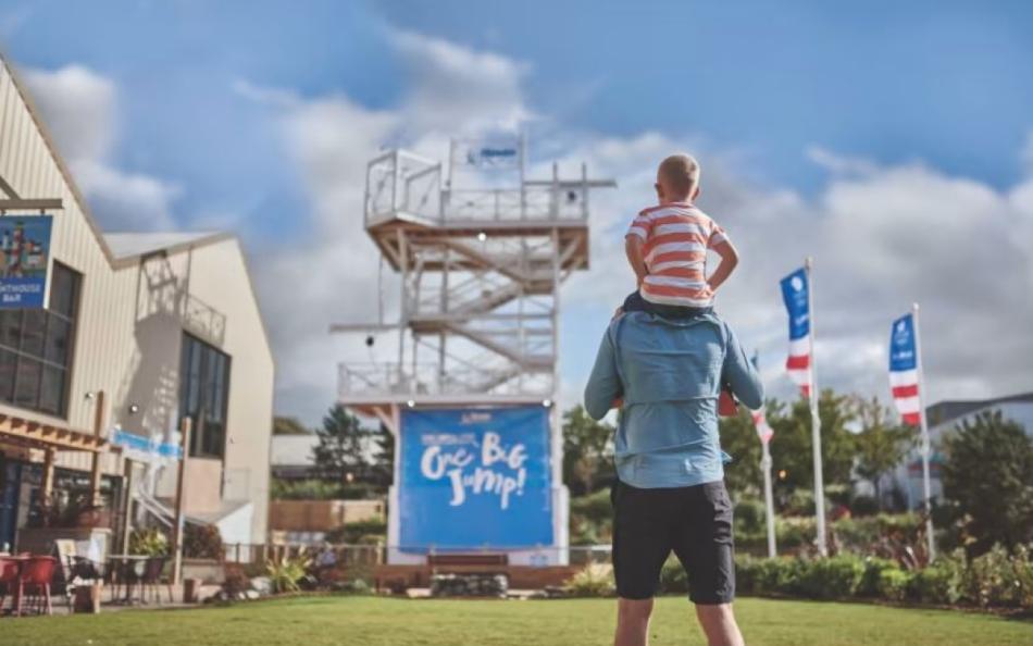 A child on it's parents shoulders in a holiday park