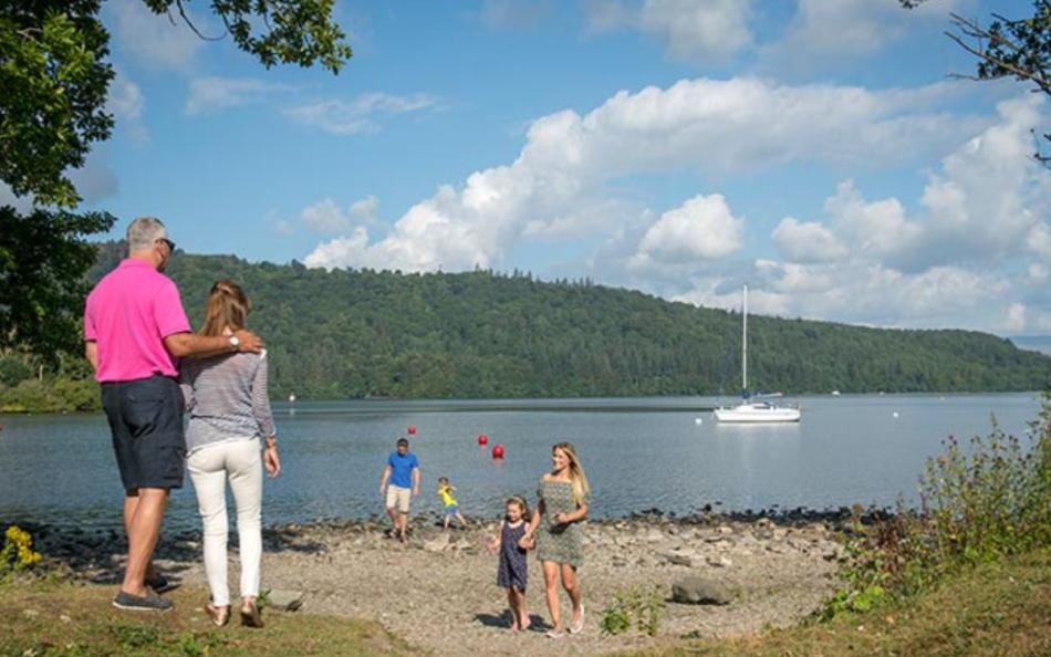 An group of people walking near the lakeside on a warm sunny day