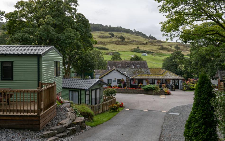 A number of holiday homes surrounded by trees and rolling hills