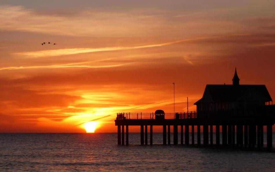 A sunset with a view of a pier 