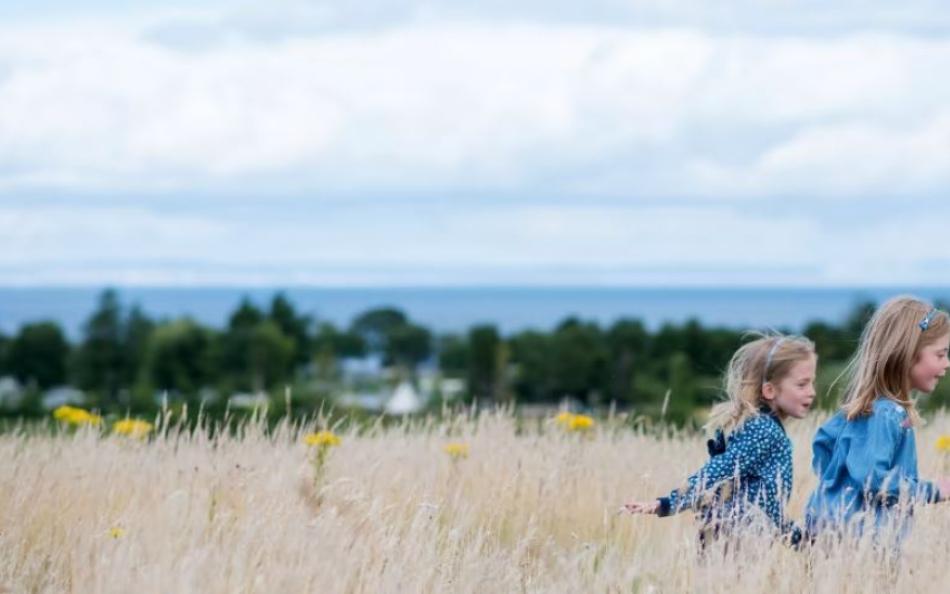 Two children running through long grass