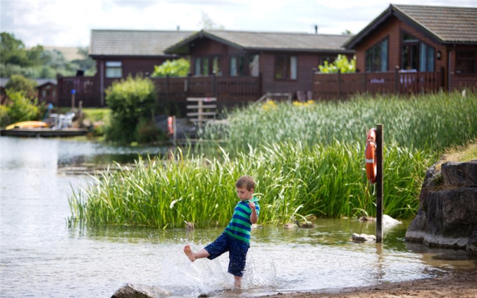 lake surrounded by holiday homes at dog friendly holiday parks in the lake district