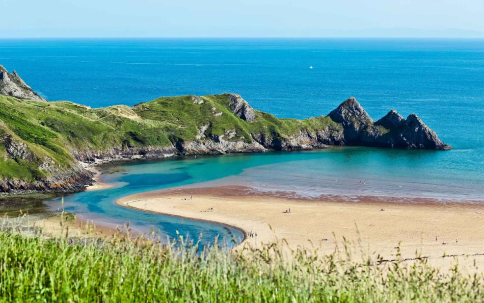 A view of the coastline as a river runs into the sea on a warm summers day