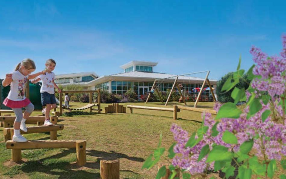 Two children playing in a play park on a bright and sunny day