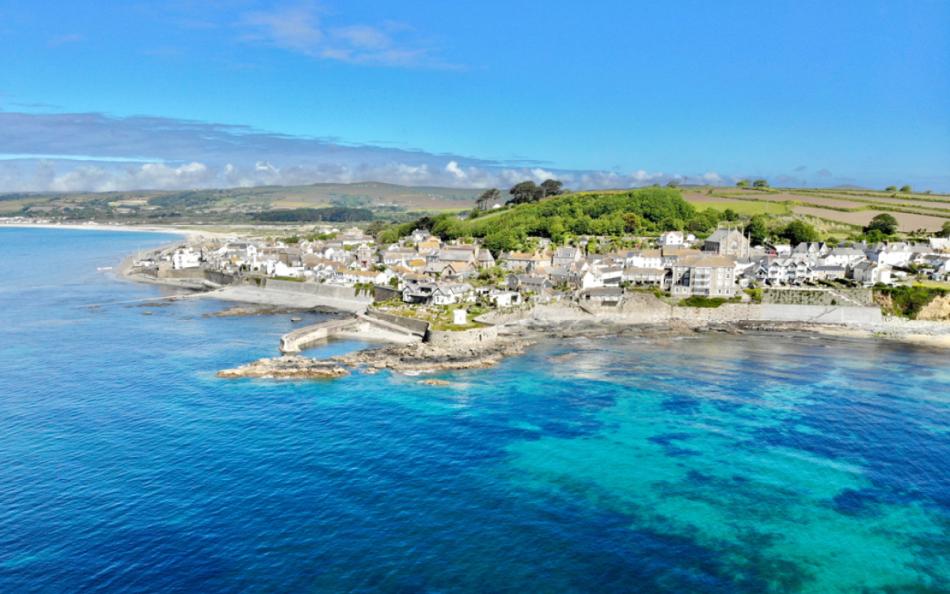 A view of a village on a sunny day next to crystal clear ocean water