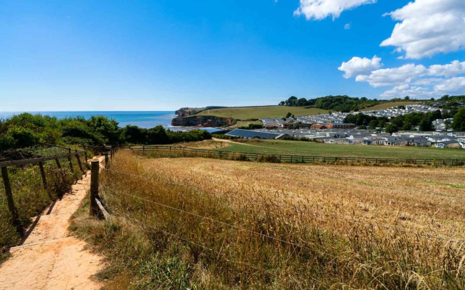 A View of a Walking Spot Nearing a Holiday Park set against the Coastline 