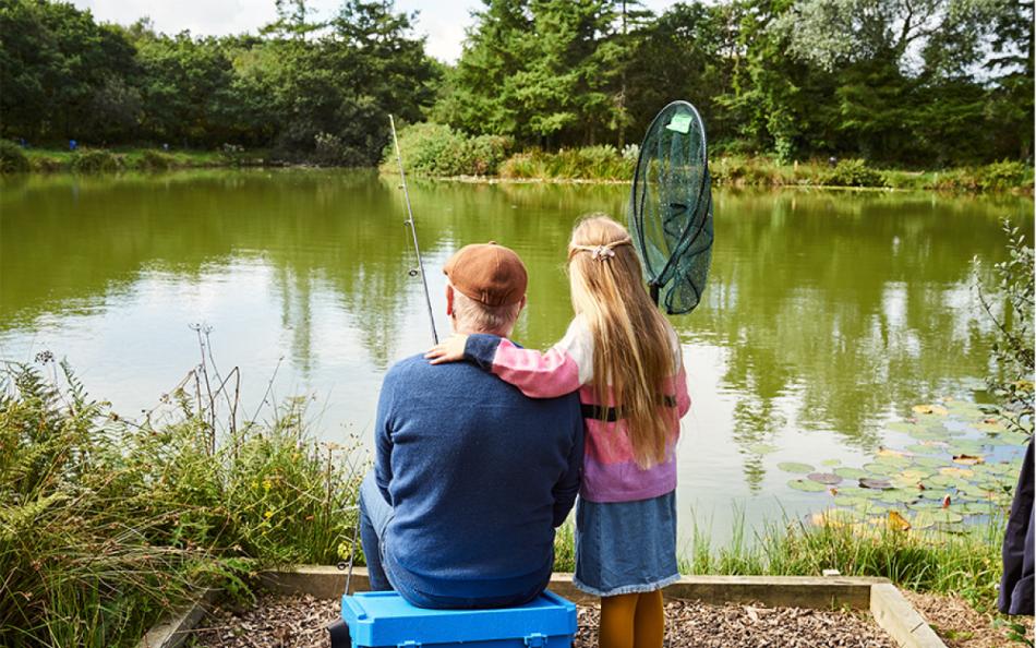 A Grandfather and Grandaughter Fishing at a Cornish Lakeside