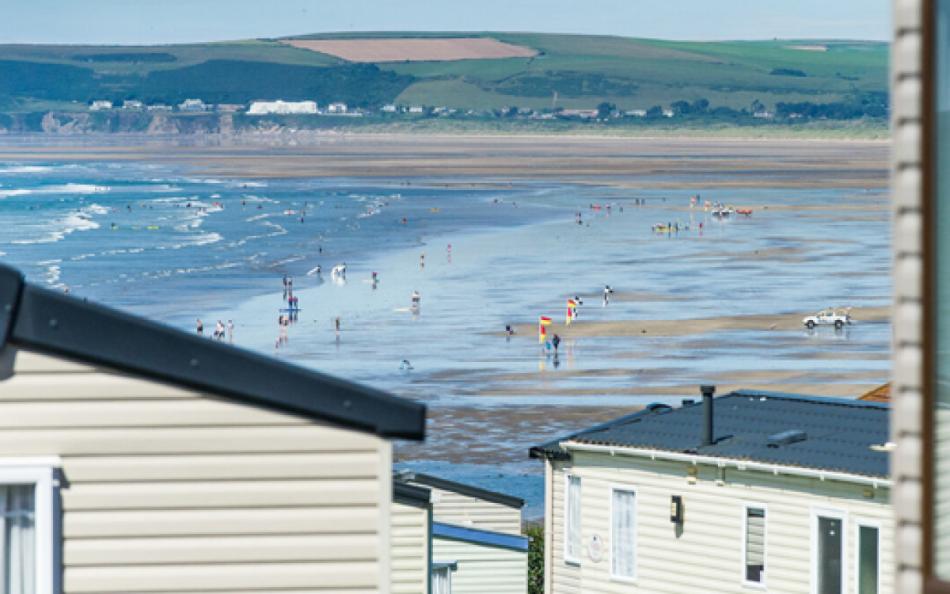 An Image of Westward Ho! Beach with Caravan Holiday Homes in the Foreground
