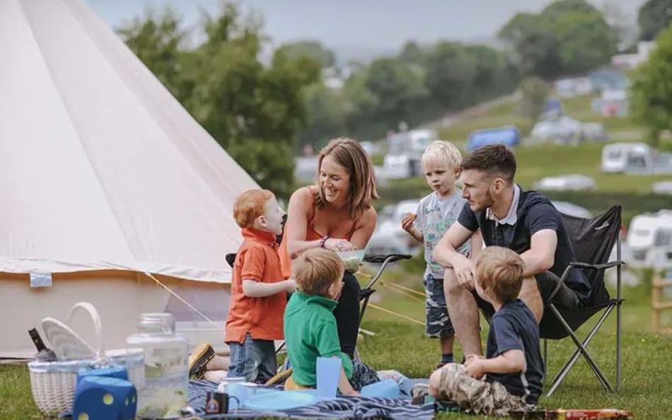 A Family Sitting Beside their Tent on a Holiday Park in Devon