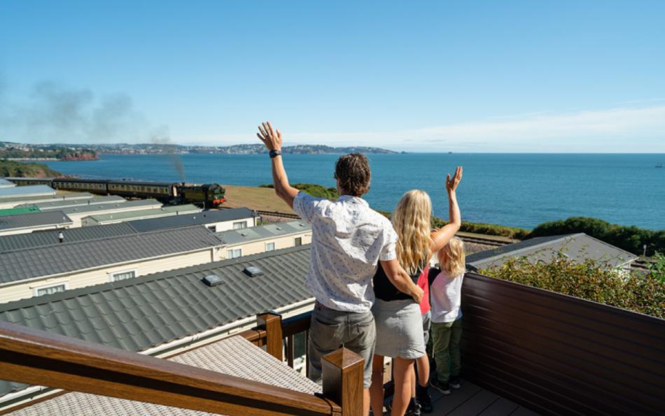 A Family Waving at the Steam Train Passangers with Far Reaching Coastal Views of South Devon