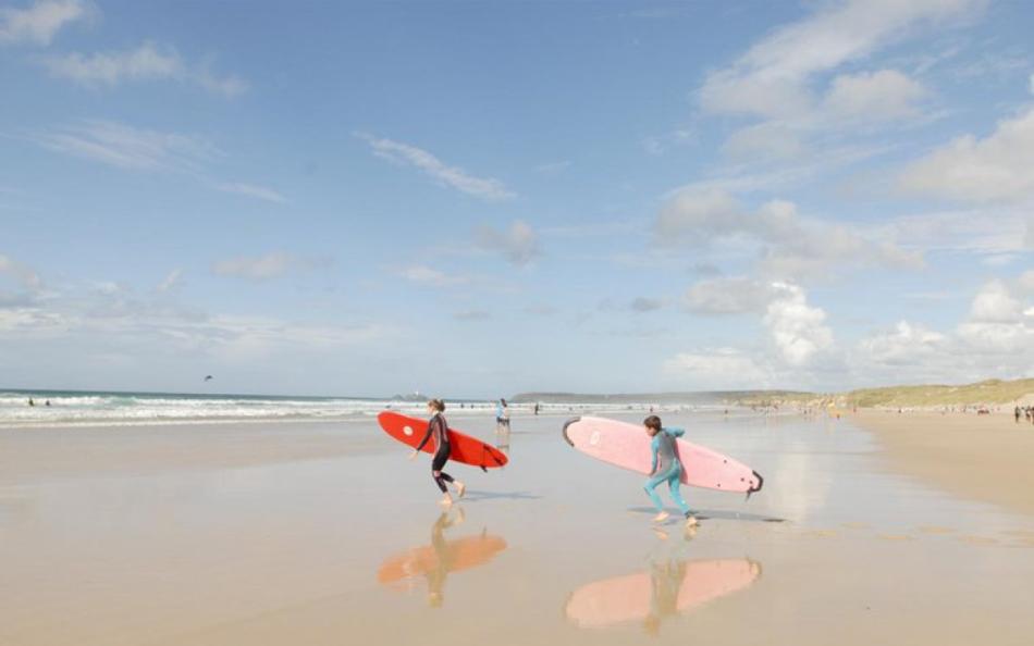 People Heading to the Surf on a Beach near St Ives Bay Holiday Park
