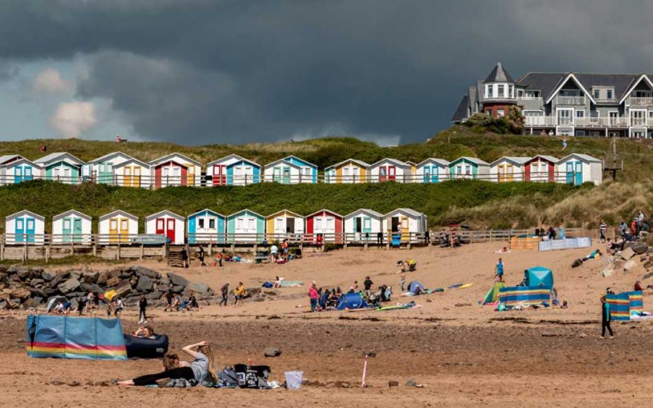 A Row of Beach Huts next to a Sandy Beach near Bude in Cornwall