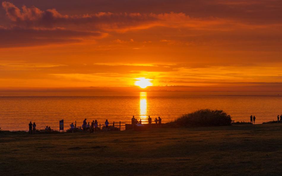 A Group of Onlookers Watching a Dramatic and Beautiful Golden Sunset a Woolacombe Beach