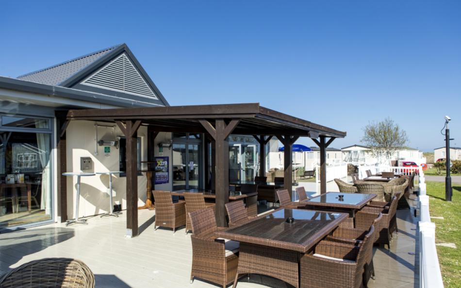 A Outdoor Dining Area with Caravan Holiday Homes in the Background