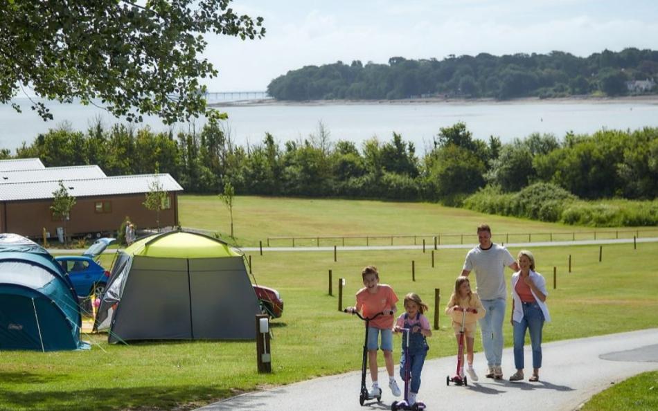 A Family Walking Through  Holiday Park near the Beach on a Bright Sunny Day