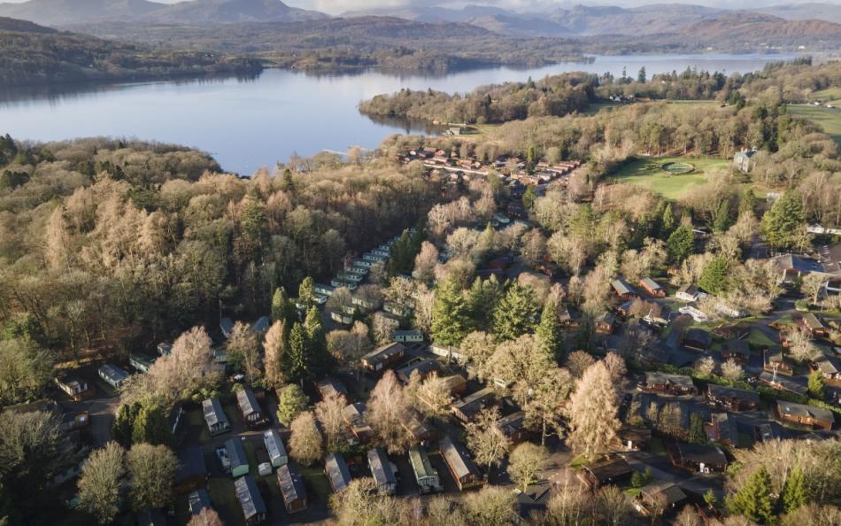 An Arial view of a Holiday Parked Nestled in the Woods at the Side of a Lake