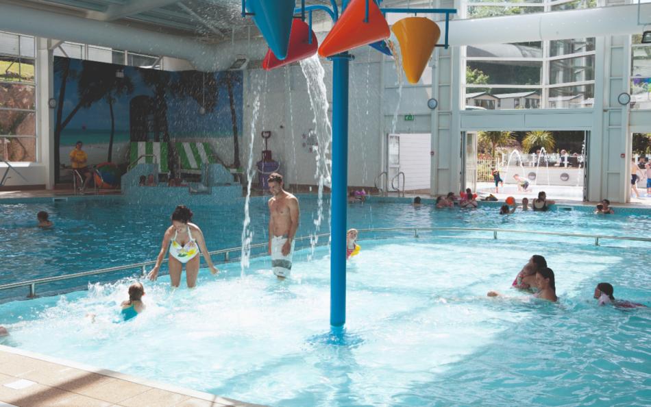 Indoor Swimming Pool with Tipping Water Buckets above People on a Holiday Park