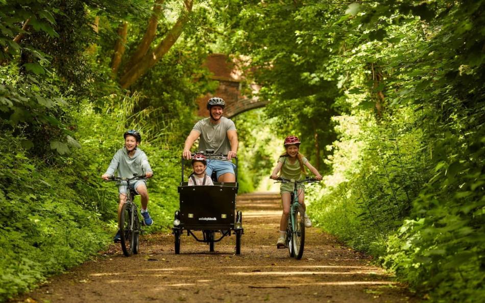 A Family riding Bikes along a Wooded Pathway