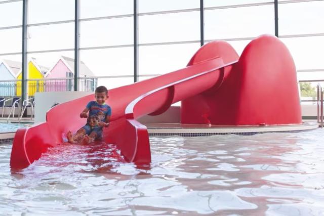 going down the slide at the indoor swimming pool