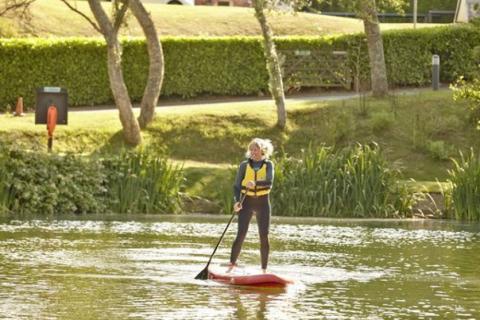having fun on a paddleboard at The Lakes Rookley Holiday Park