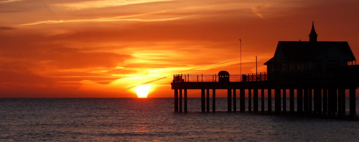 A sunset with a view of a pier 